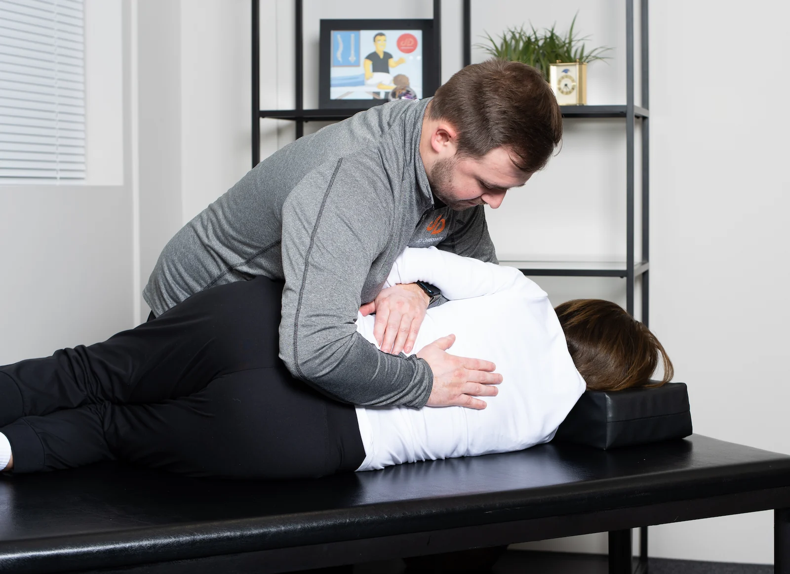 JD Osteopathy practitioner treating a patient in a sideline position with hands on the patient's back